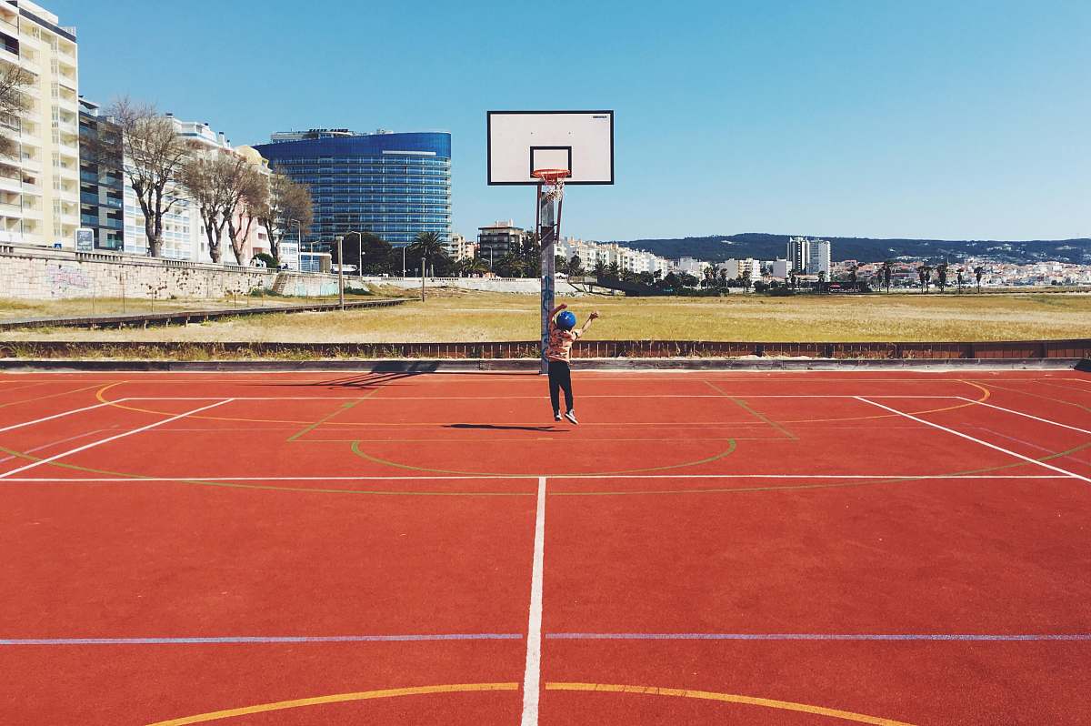 person girl jumping near basketball court during daytime sport