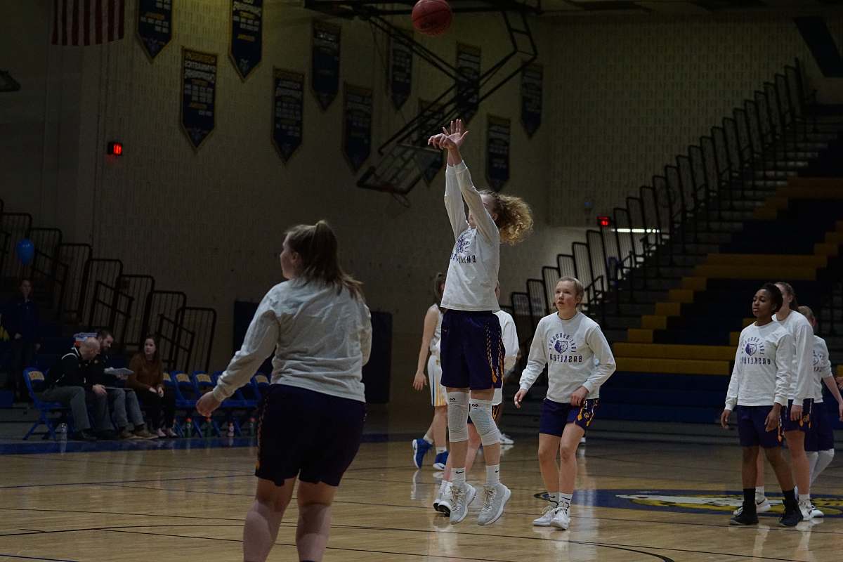 person girl playing basketball inside court apparel