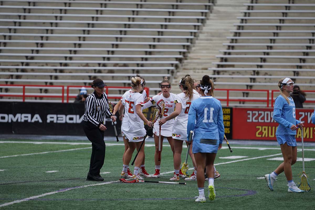 person girl playing lacrosse in field people
