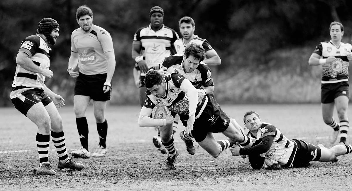 team gray scale photo of person playing football black-and-white
