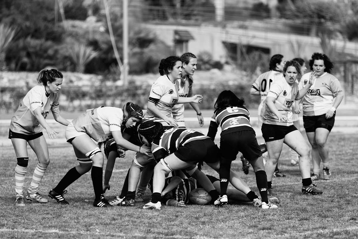 person gray scale photography of women playing football on field black-and-white