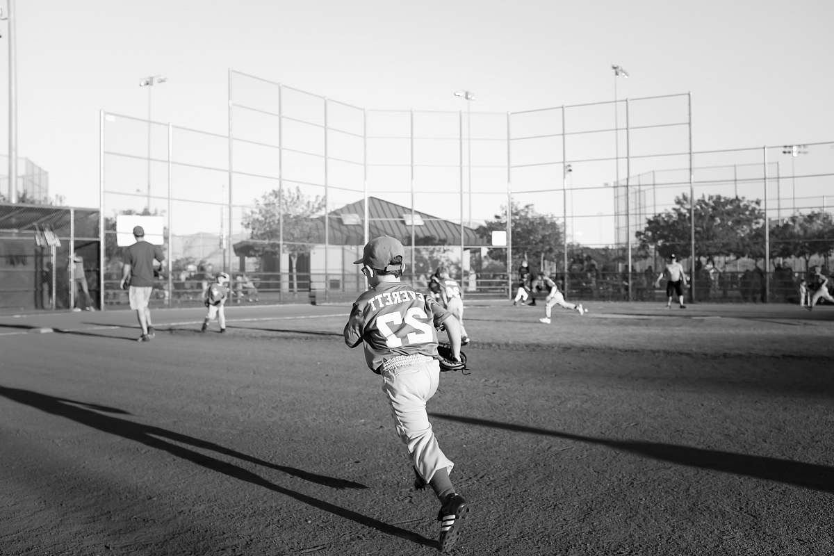 people grayscale photo of children playing baseball black-and-white