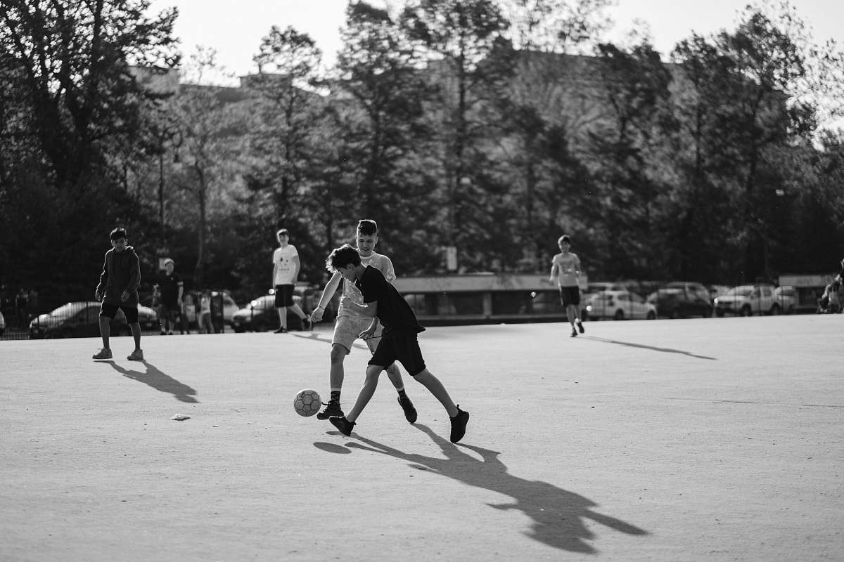 people grayscale photo of group of man playing soccer on field black-and-white