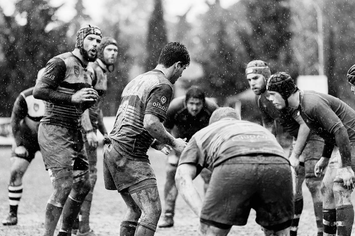 black-and-white grayscale photo of group of people on football field people