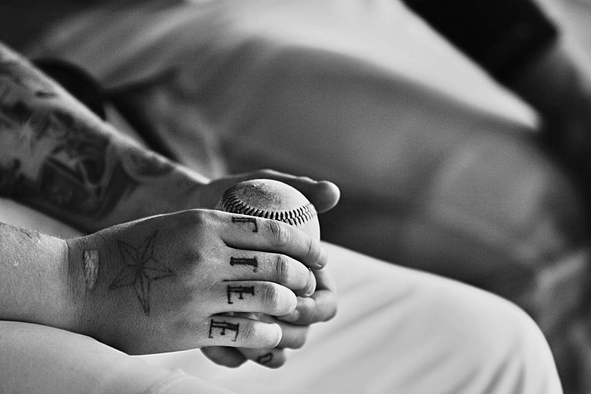 black-and-white grayscale photography of person holding baseball ball skin