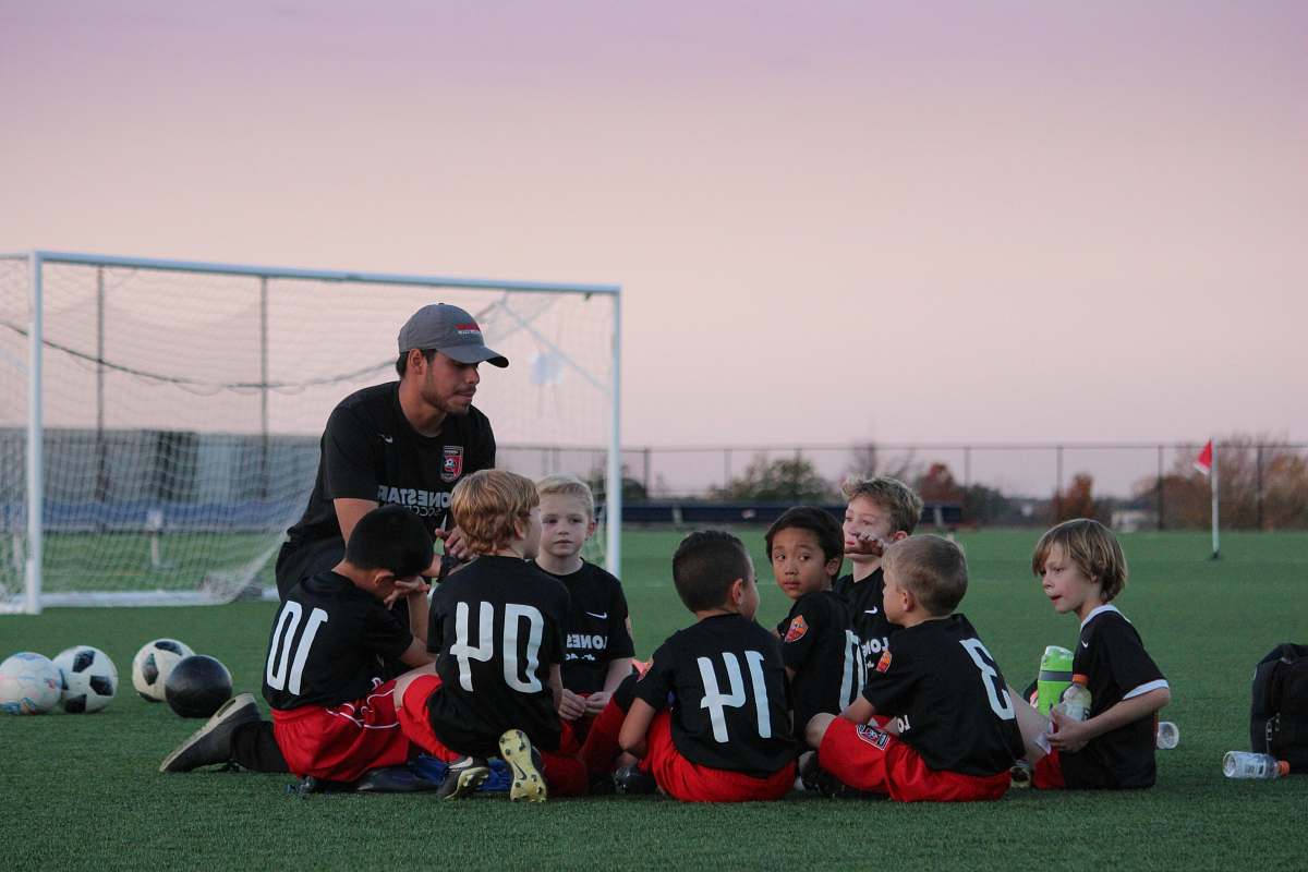 person group of boys sitting on ground apparel