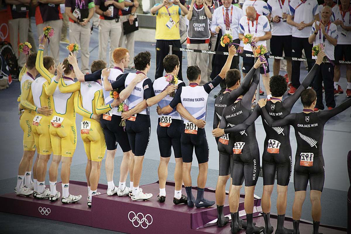 person group of men standing in podium holding flowers people