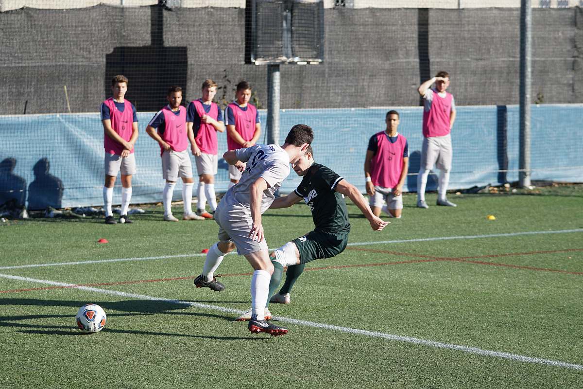 Capture the energy and excitement of a vibrant soccer match as a group of young men showcases their skills on a sunny field. This image encapsulates the passion and camaraderie of team sports, making it perfect for promoting athletic events, youth leagues, or sports-related content. The bright daylight enhances the action, making it an ideal choice for magazines, websites, or promotional materials focused on sports and outdoor activities.