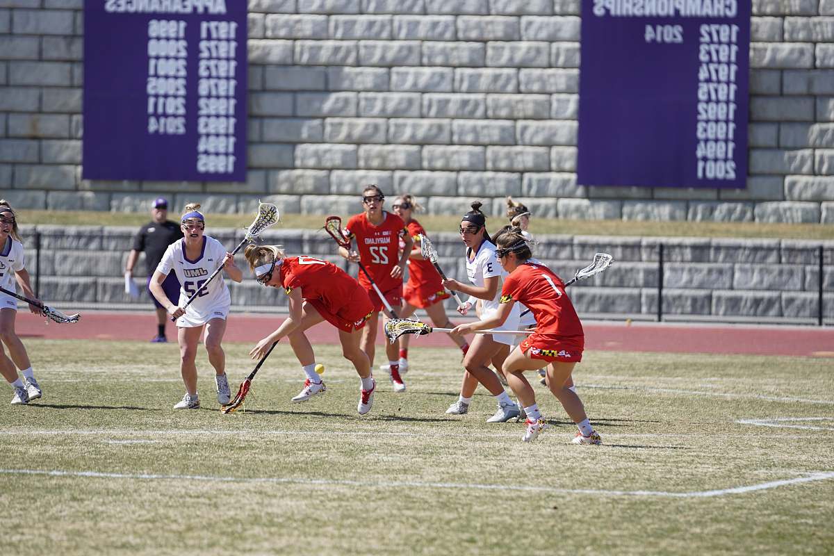 person group of woman playing lacrosse during daytime people