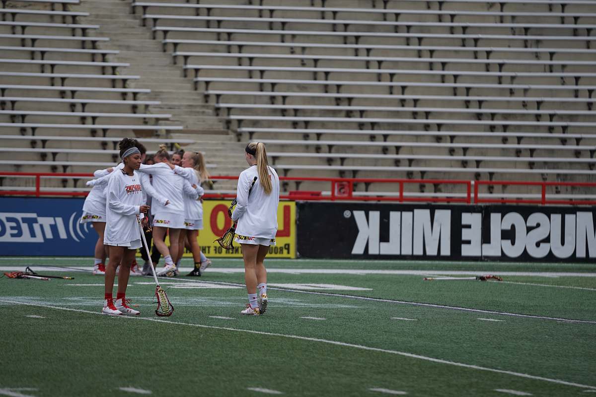 person group of women playing hockey on field field