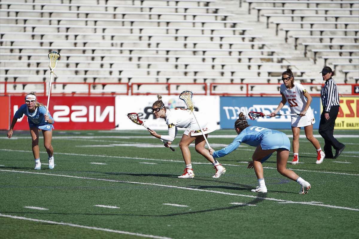 person group of women playing lacrosse on field apparel