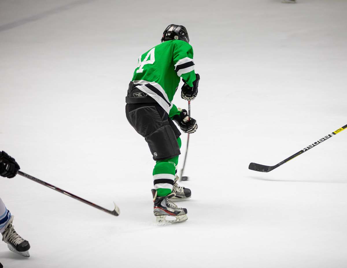person hockey player wearing green jersey people