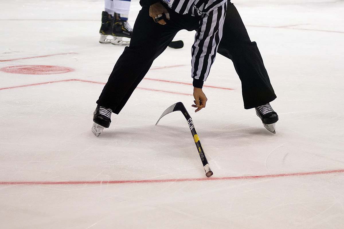 person ice hockey referee on ice rink sport