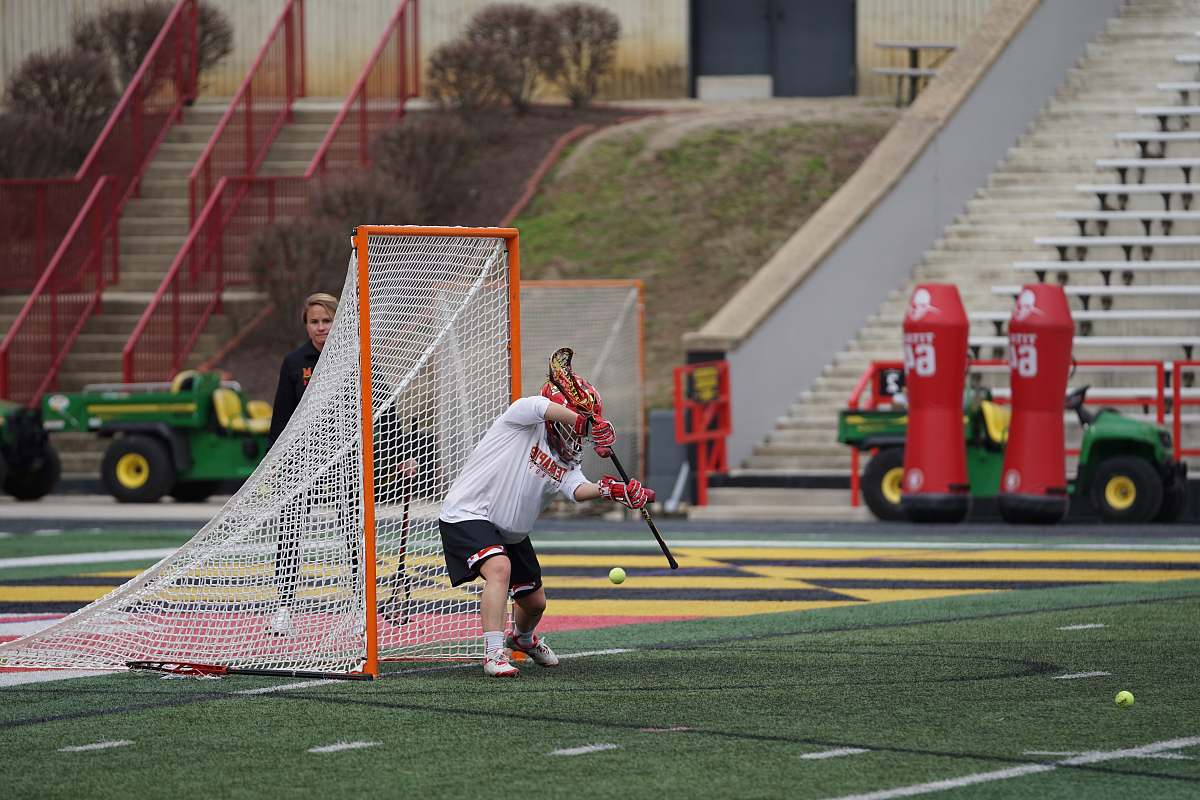 hockey lacrosse goalie defending goal on field at daytime people