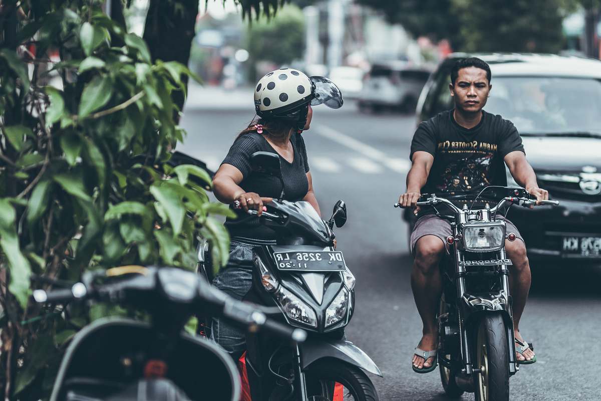 person man and woman riding on motorcycle at daytime motorcycle