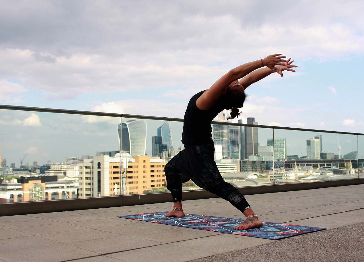 person man doing yoga on rooftop people