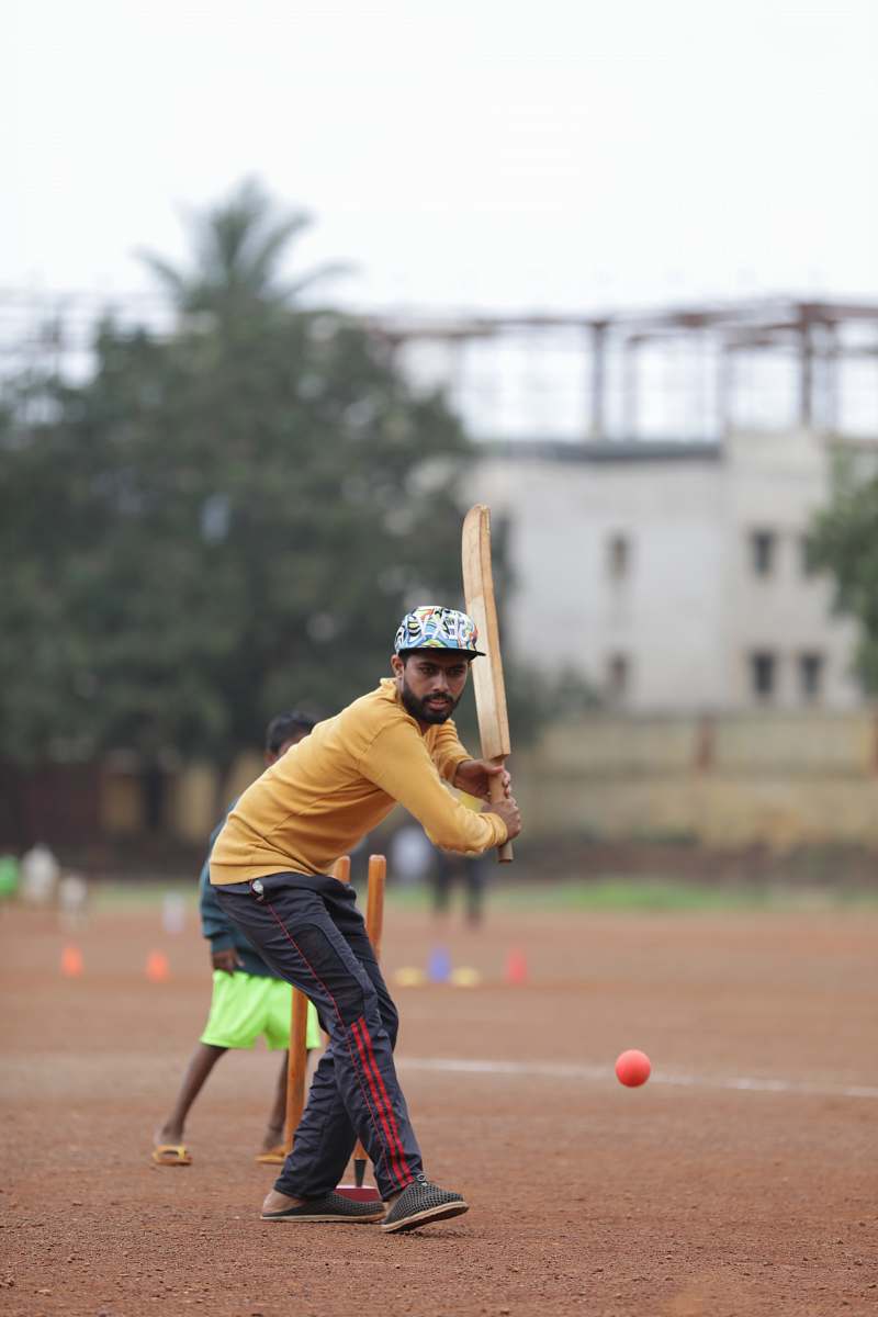 person man holding cricket bat on field clothing