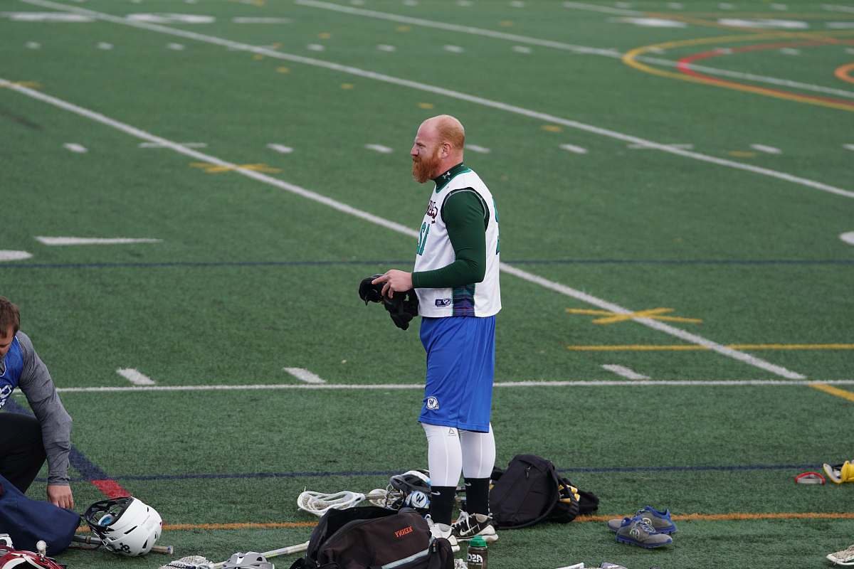 person man holding helmet on field apparel