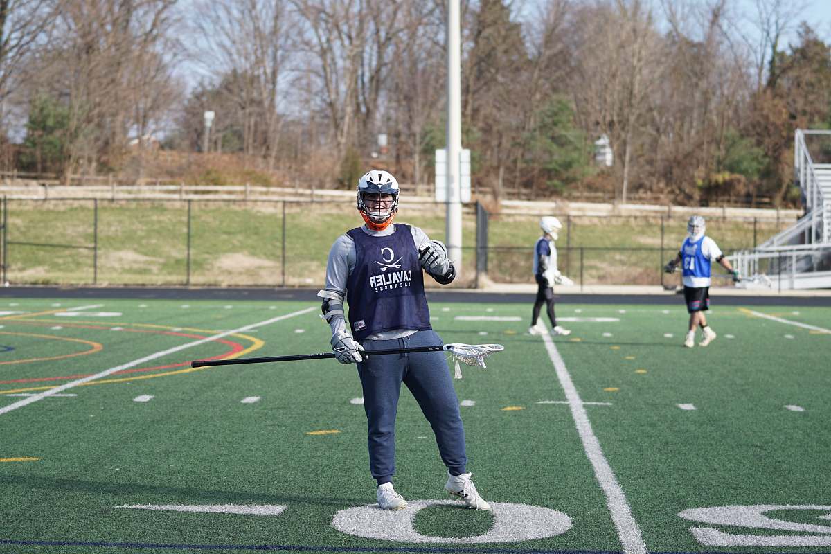 person man holding lacrosse stick apparel