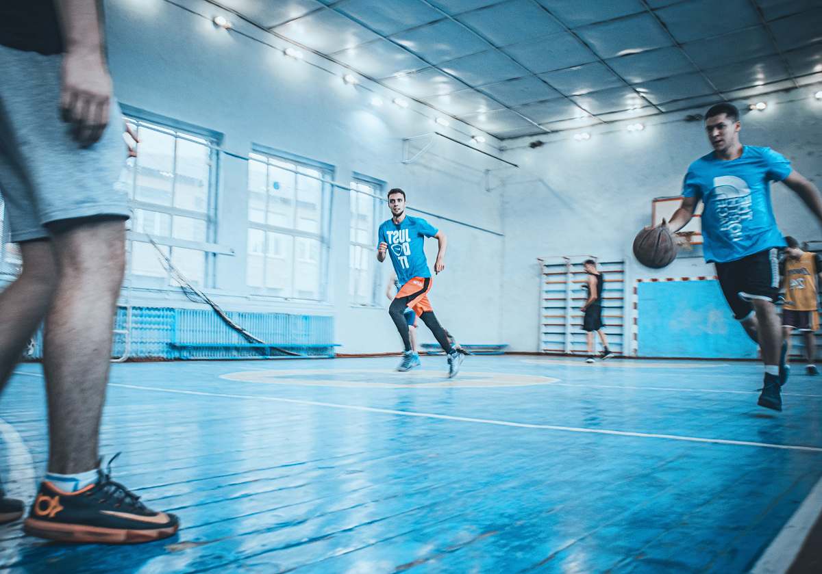 people man in blue t-shirt dribbling basketball person