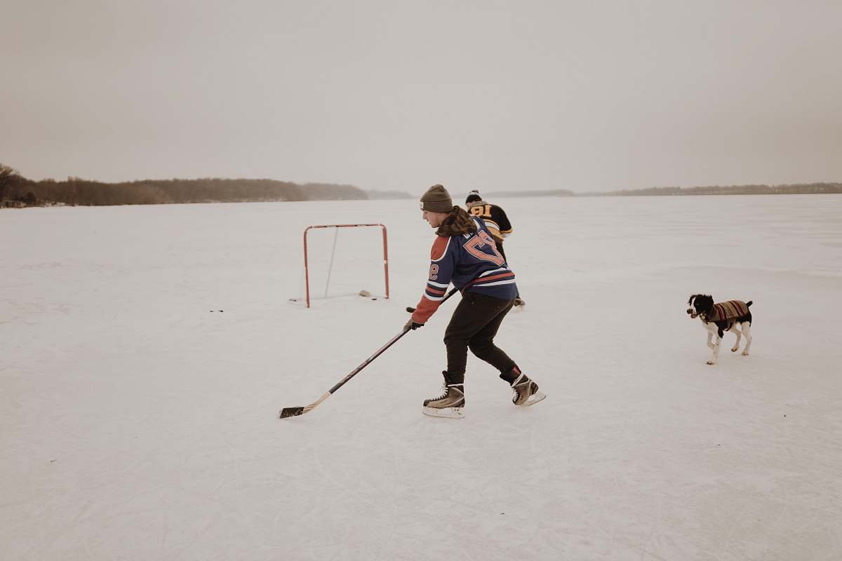 person man playing ice hockey dog