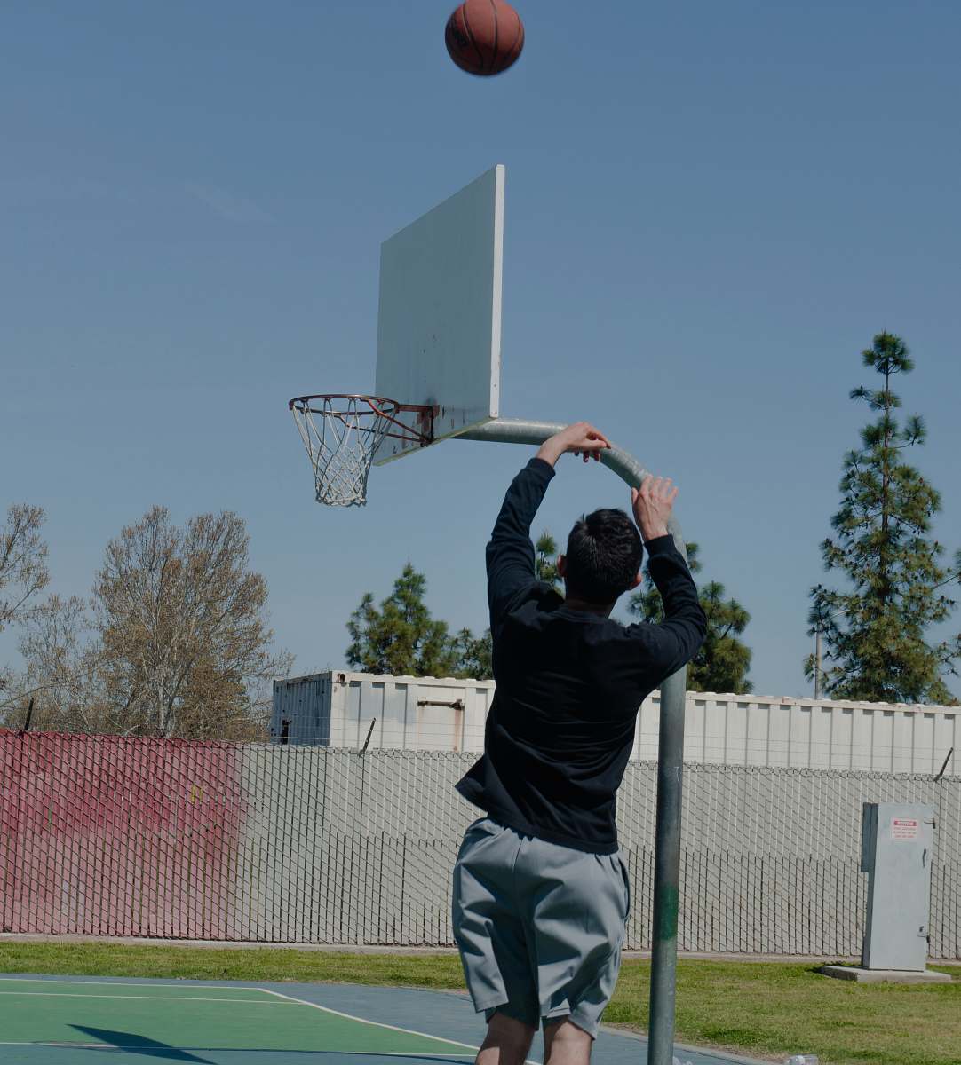 person man shooting ball on hoop during daytime people