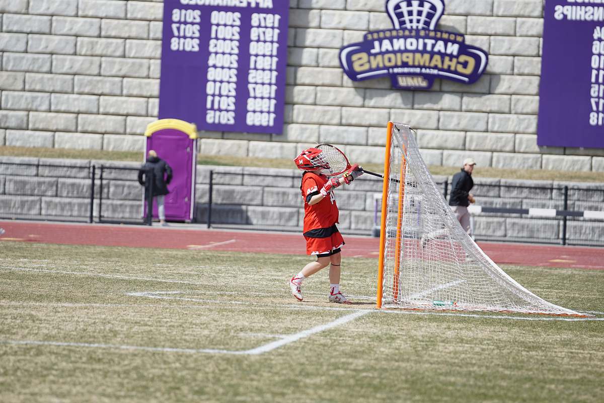 person man standing in front of orange and white goalie people