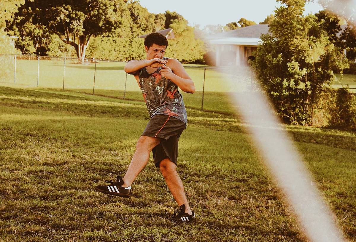 person man standing on green field apparel