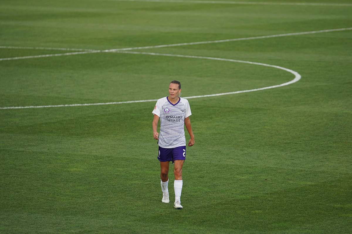 person man standing on soccer field during daytime people
