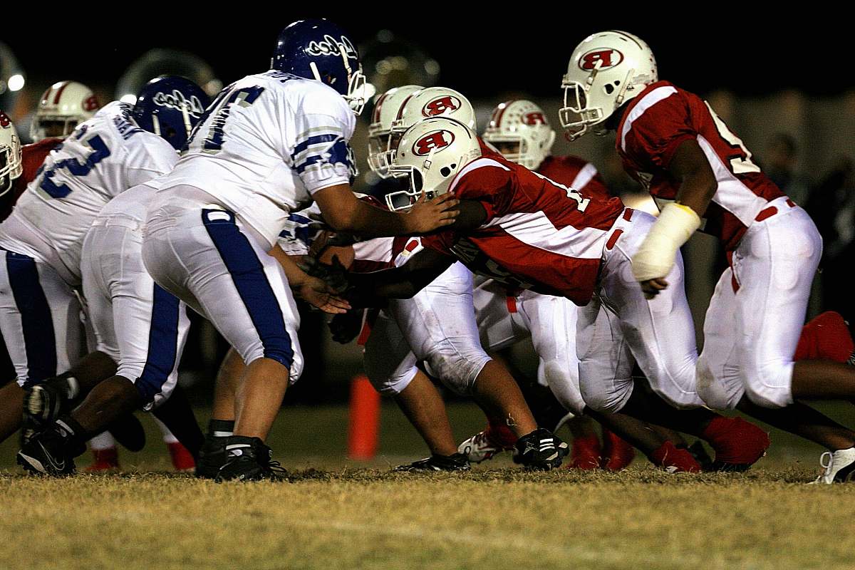 helmet men playing American football on green grass field football