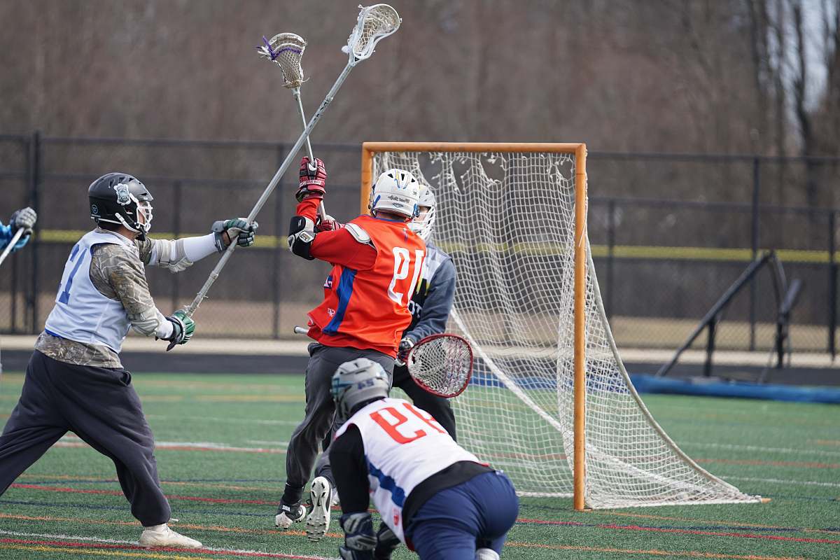 person men playing lacrosse during daytime apparel