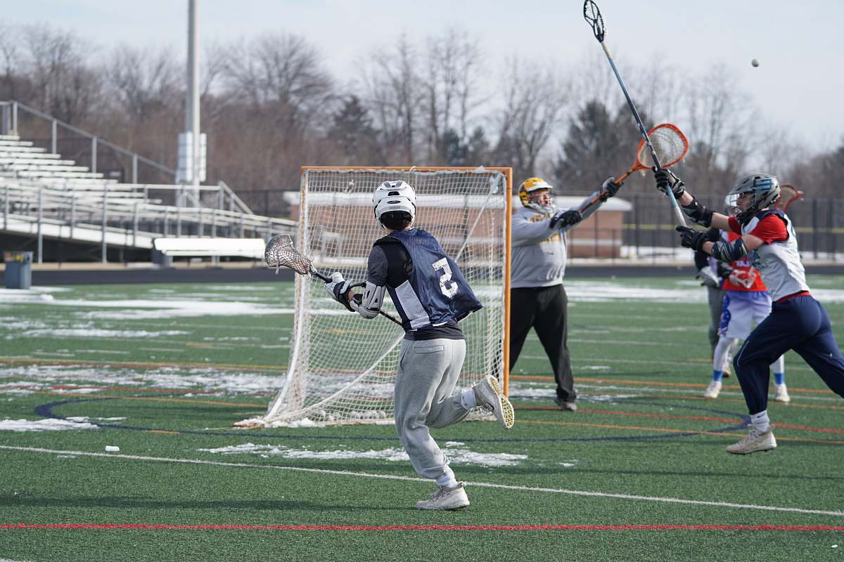person men playing lacrosse on field with snow people