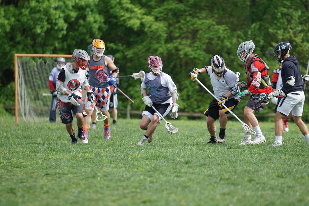 person men playing lacrosse stick at daytime apparel
