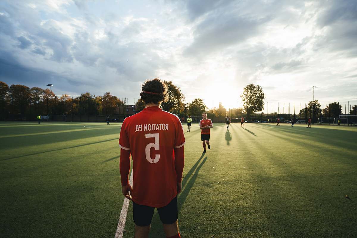 person men standing at the soccer field during day apparel