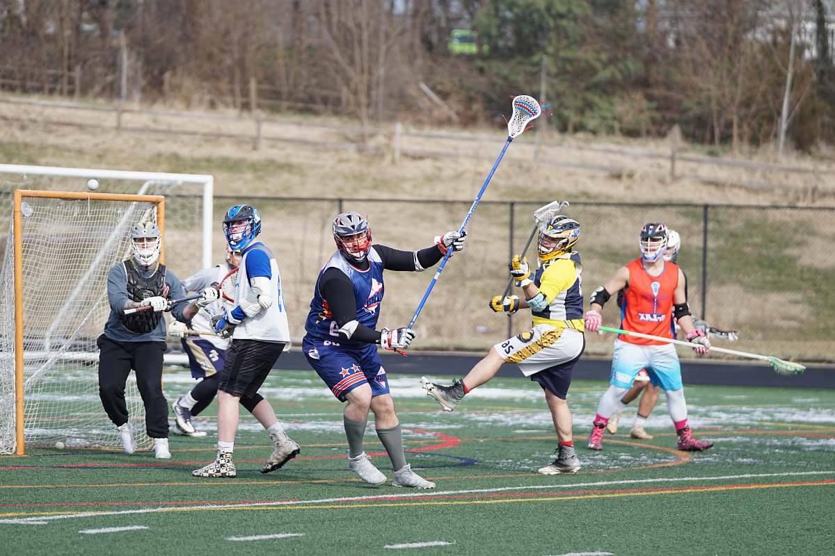 apparel people playing lacrosse during daytime person