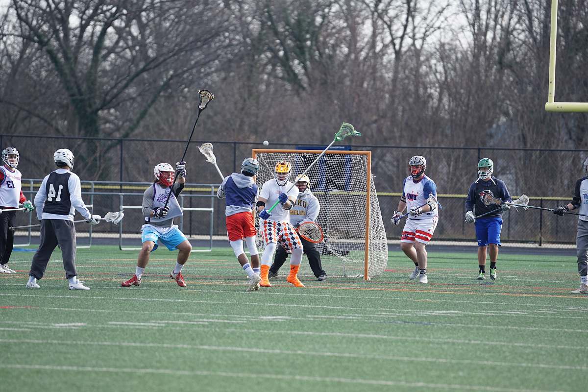 person people playing lacrosse on field people