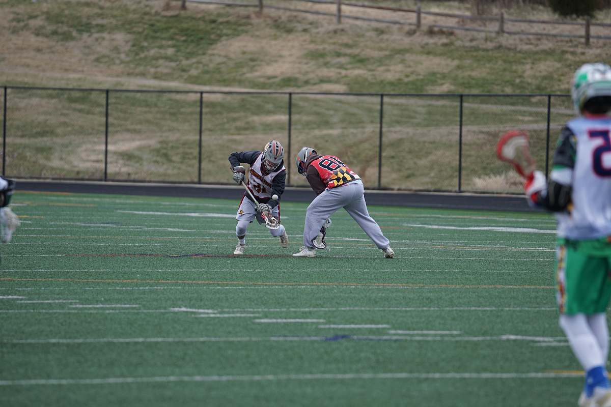 person people playing lacrosse on green field during daytimne people
