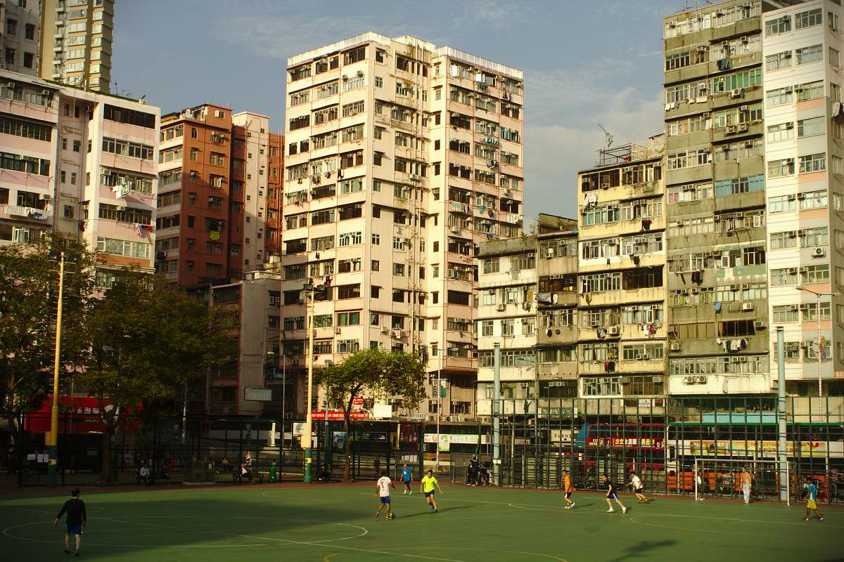 person people playing soccer under blue sky building