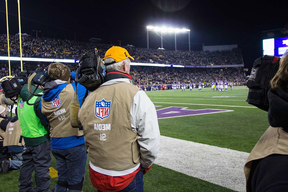 person people standing and watching NFL game in green field people