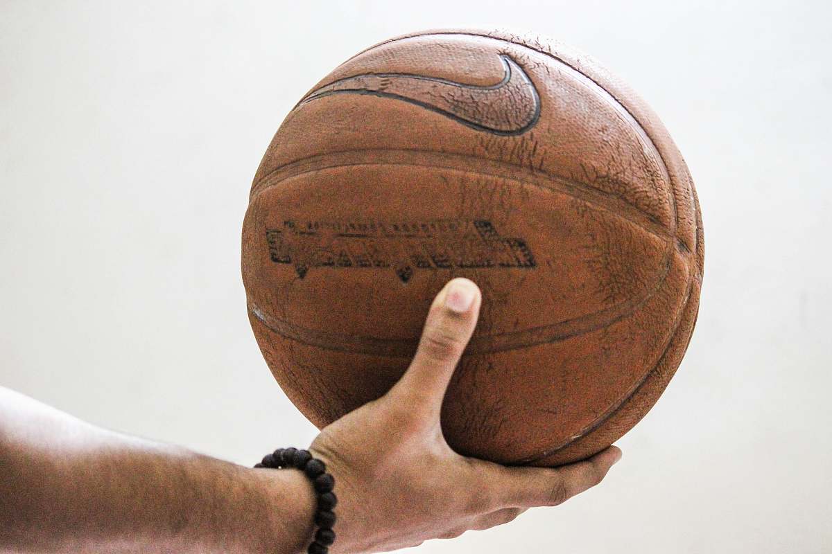 person person holding brown Nike basketball people