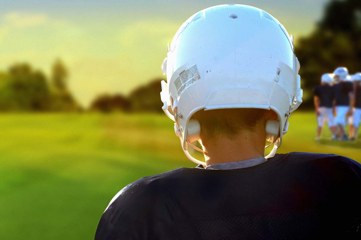 person person wearing NFL helmet during daytime people