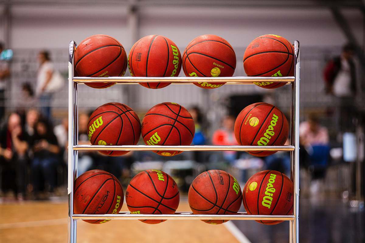 person pile of basketballs on rack sphere