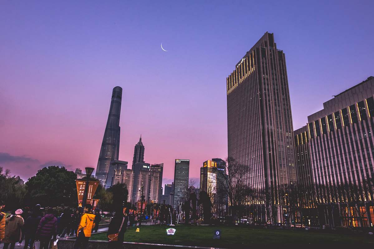 person purple and blue sky over high rise skyscrapers at dusk building