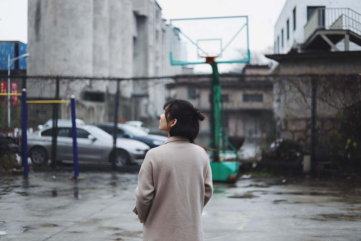 person selective focus photography of woman standing near basketball hoop apparel
