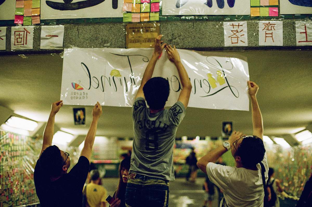person three men putting signage apparel