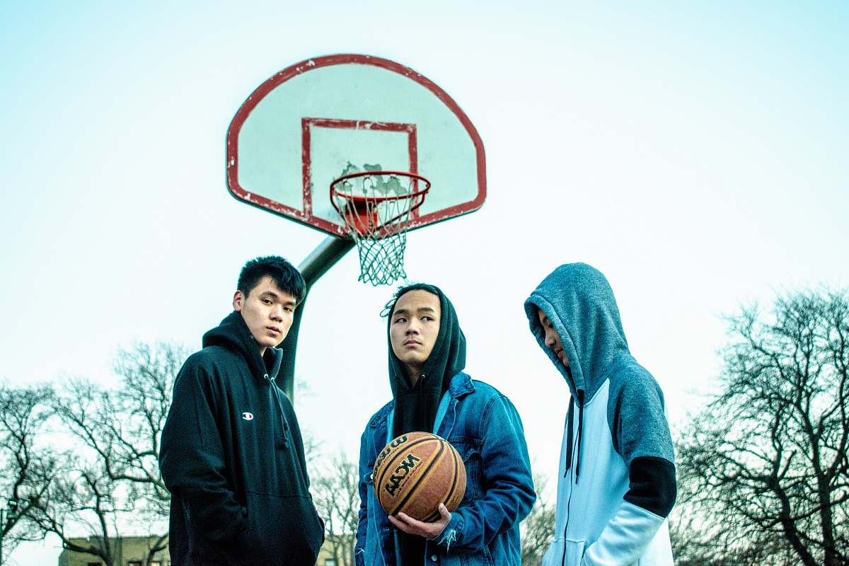 people three men wearing hoodie near basketball hoop person