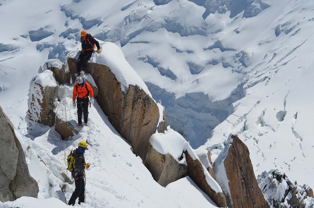 people three person trekking on snow field mountain at daytime mountain