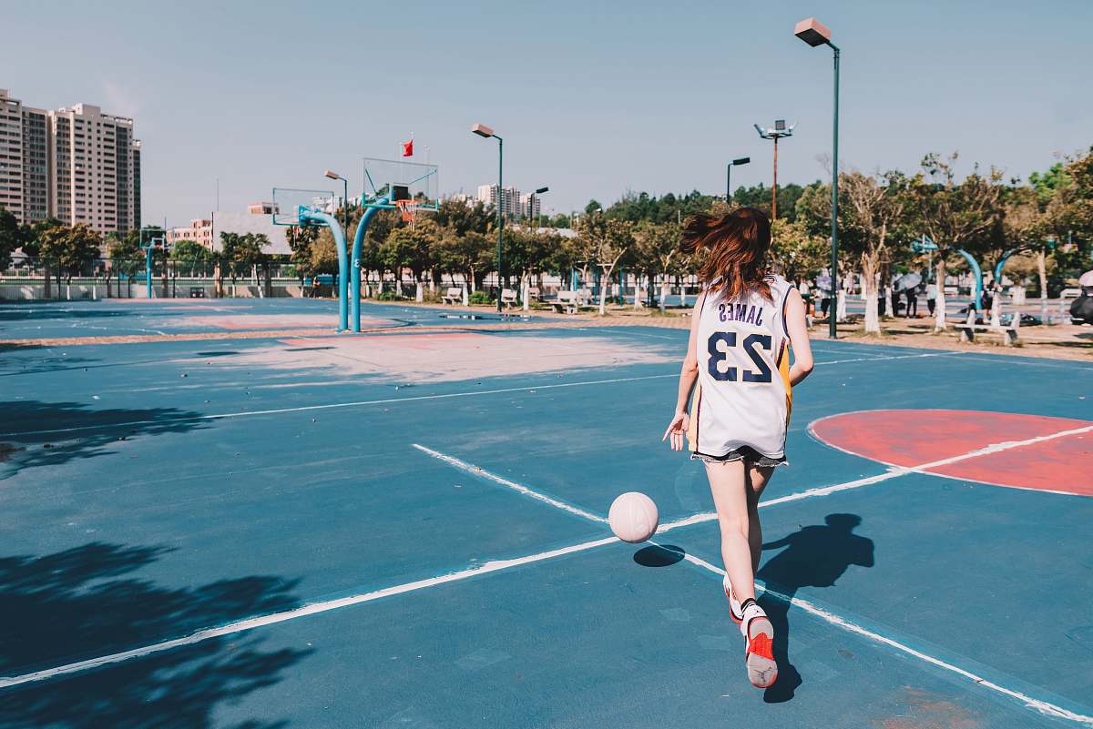 person time lapse photography of woman dribbling a ball people