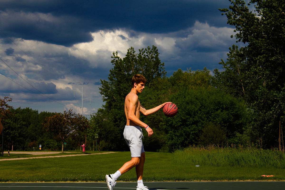 person topless man holding basketball during daytime people