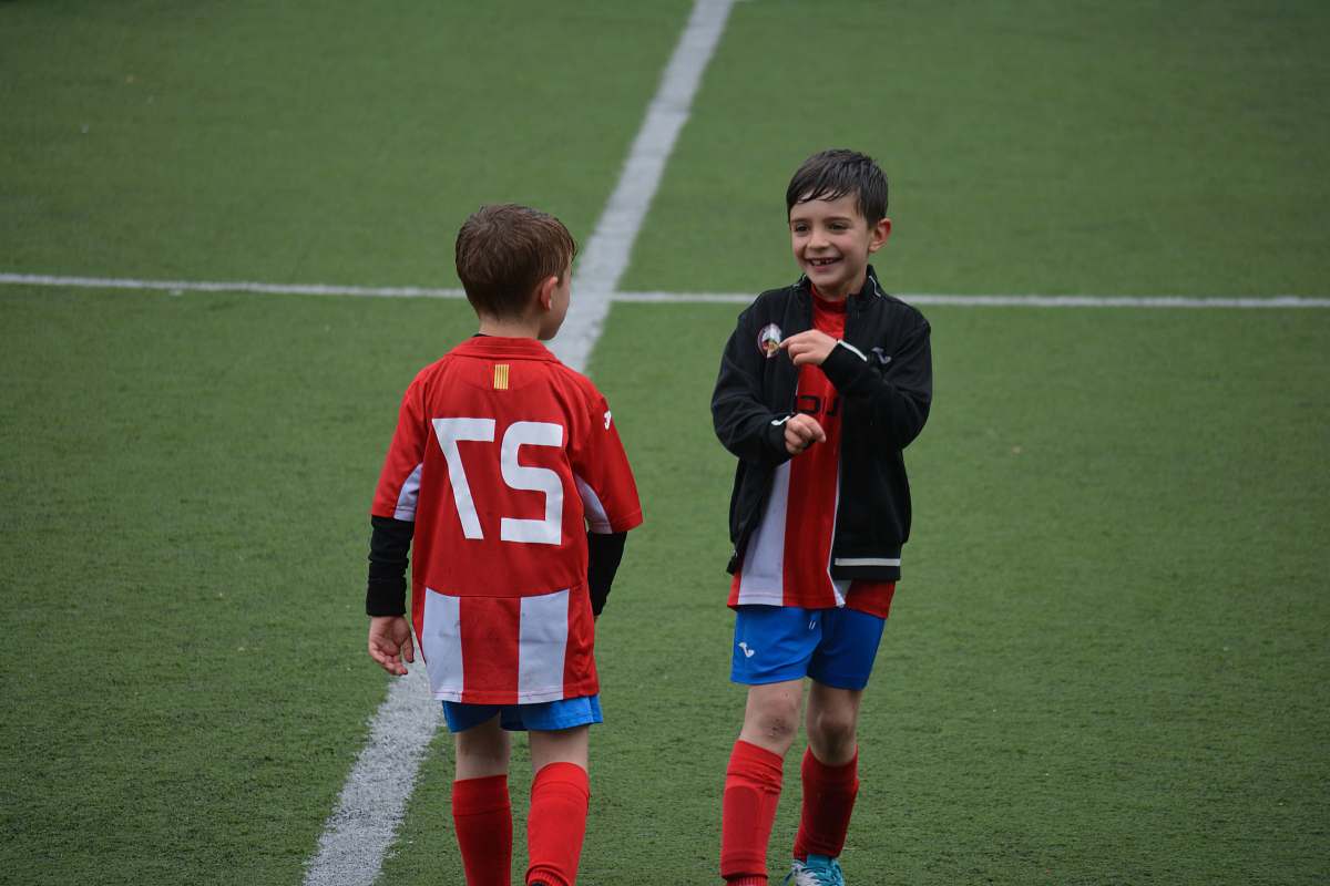 person two boy standing on soccer field people